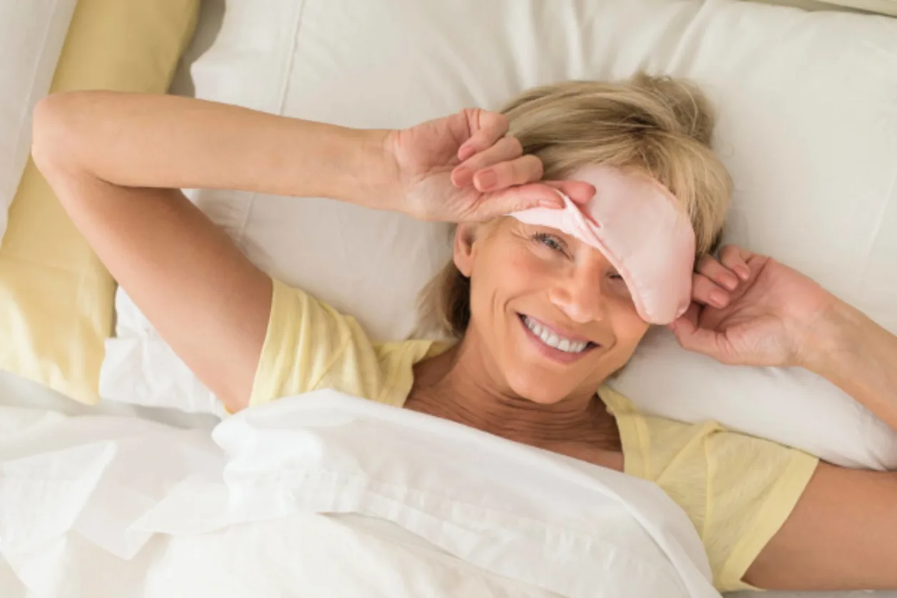 Mature woman wearing sleep mask in bed good sleep hygiene concept